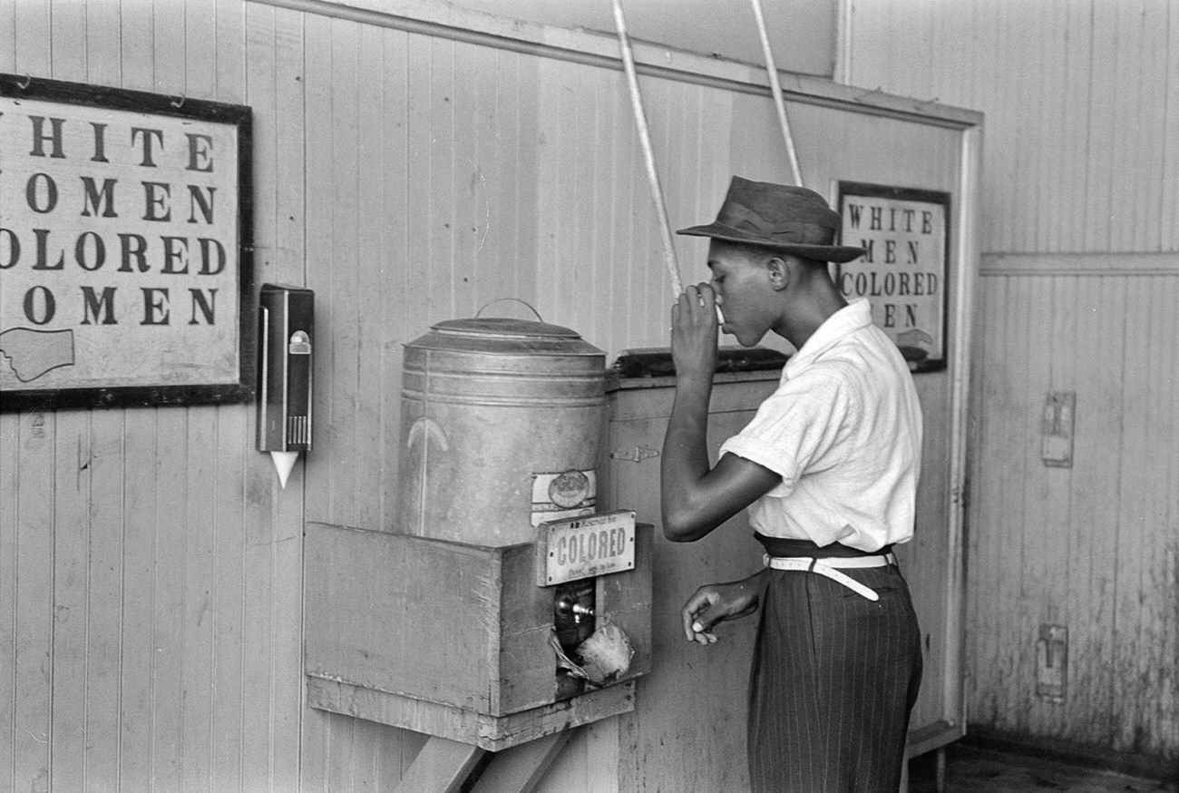 A man drinking at a "Colored" water cooler in Oklahoma City, Oklahoma, 1939.