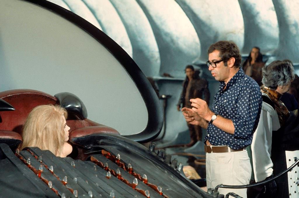 Jane Fonda ensconced in the “excessive machine” on the set of Barbarella, 1968. At right is her husband, the director Roger Vadim.