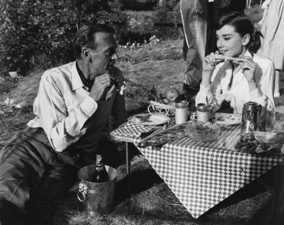 Audrey Hepburn & Gary Cooper sharing a picnic. On the Paris set of the film 'Love in the Afternoon', 1956.