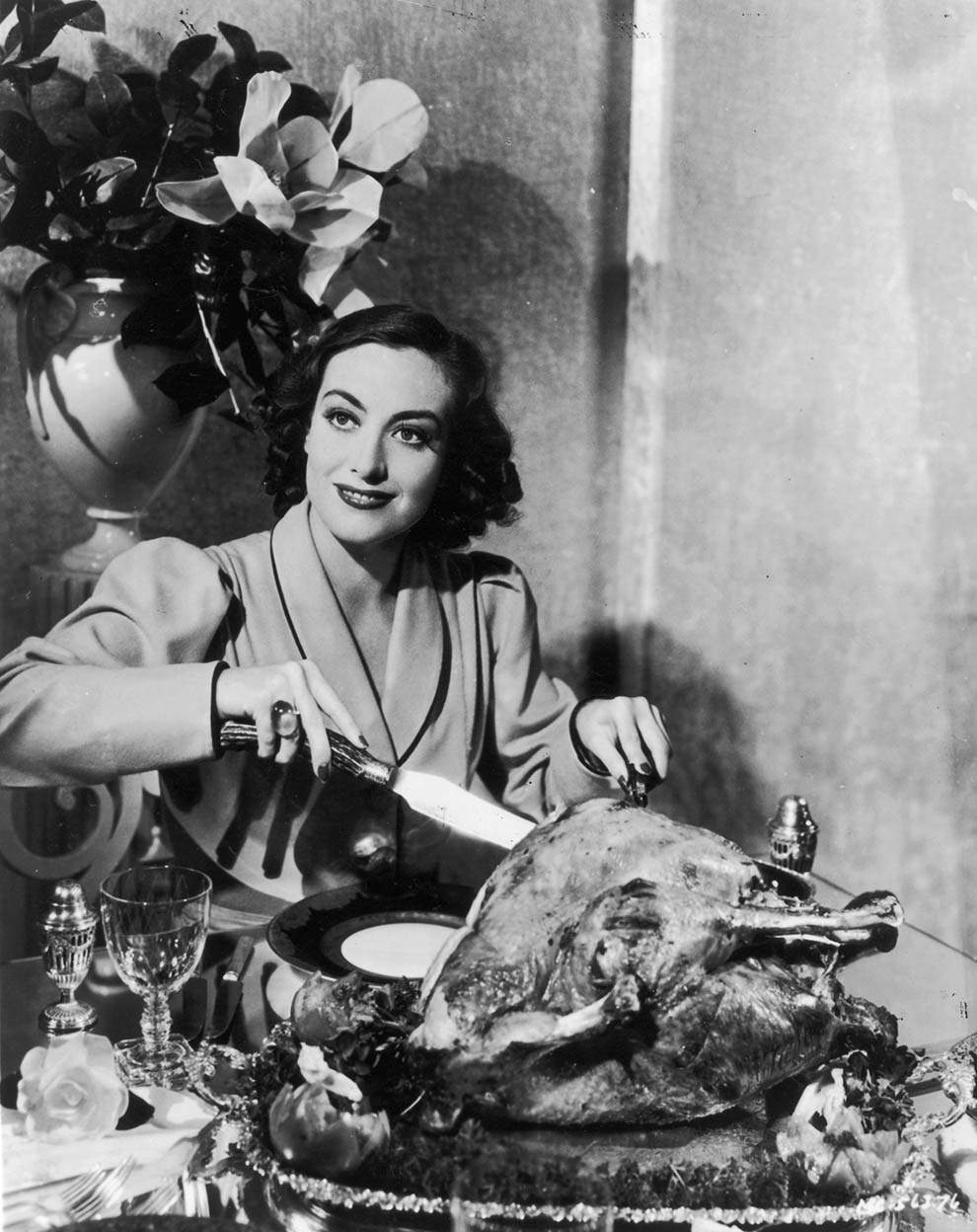 Joan Crawford carving a turkey. For a publicity shot,1930.