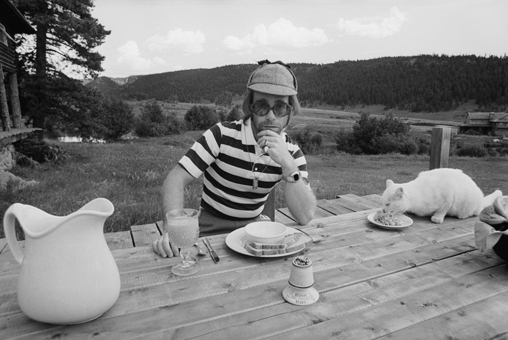 Elton John dining al fresco with his cat. At Caribou Ranch, Colorado,1974.