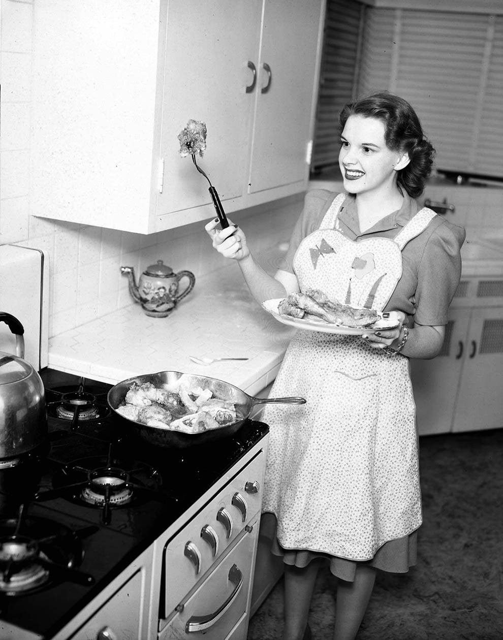 Judy Garland frying chicken. Circa 1955.