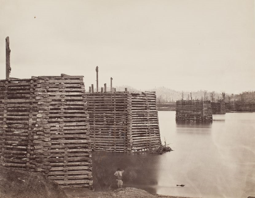 Wooden piers of a wagon bridge across the Tennessee River at Chattanooga (looking north), 1865