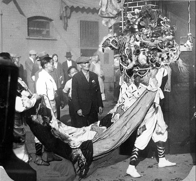 The Chinese Lion collecting gifts during New Year's celebrations in Los Angeles' Chinatown, 1930.