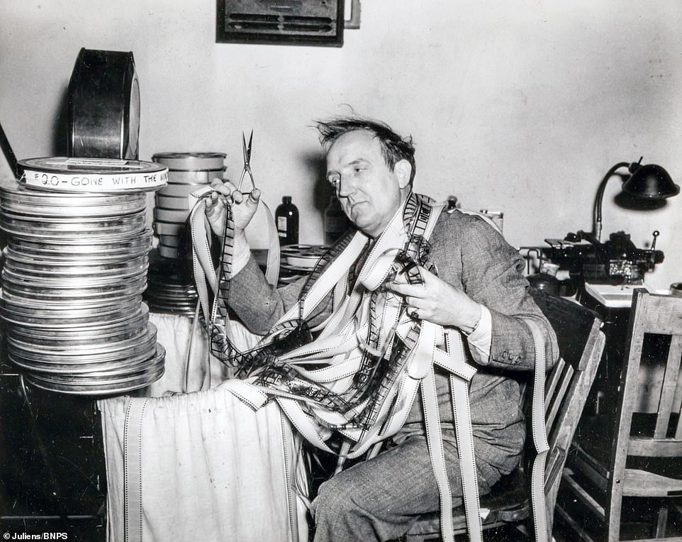 An editing department employee with rolls of film on the set of Gone With the Wind.