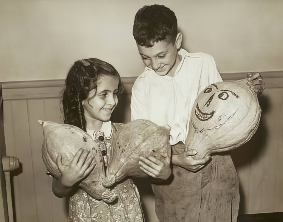 Wesson Teebagi and Nusray Hadayia holding squashes decorated with faces, 1938