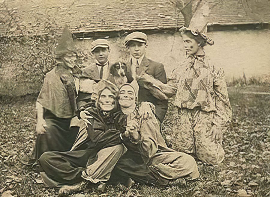 A family celebrates Halloween in the garden with homemade masks, 1905