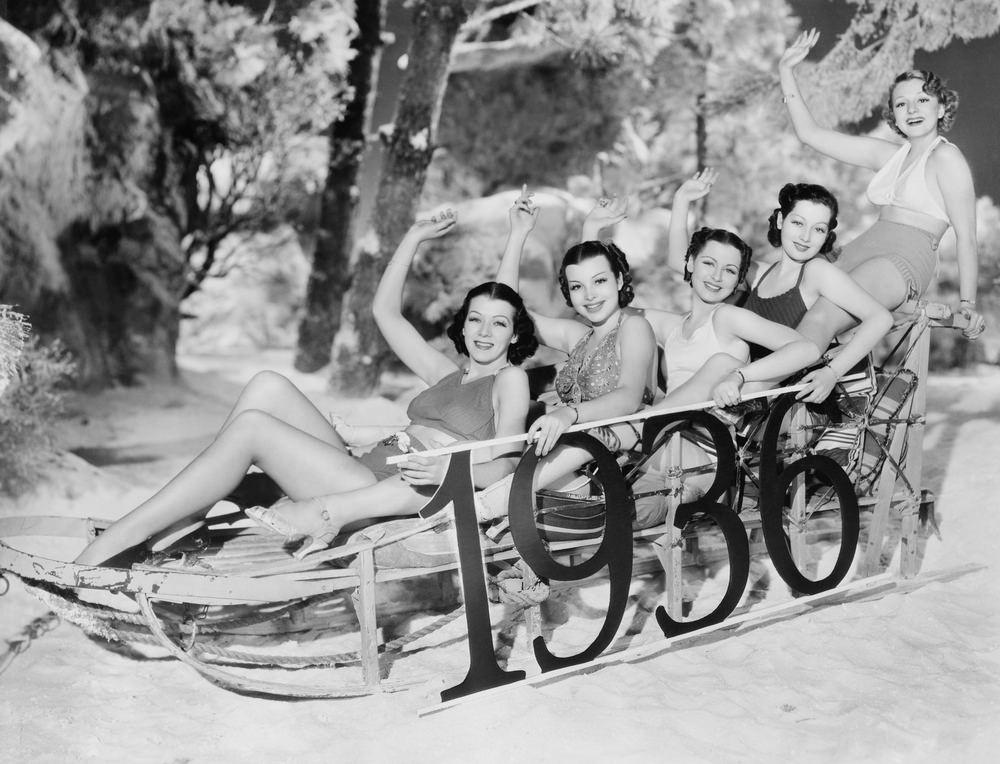 A group of women enjoy a New Year's sledding party.