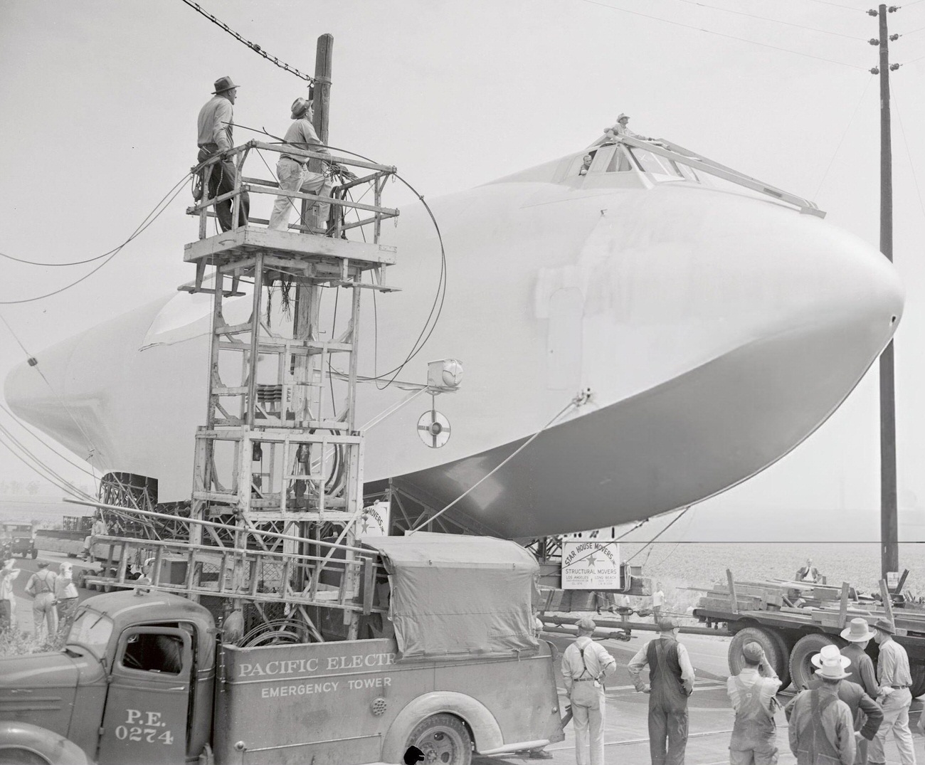 Power lines being removed for the Spruce Goose's transport, 1940s.