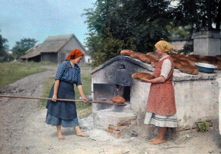 Two peasant women bake bread with an old-fashioned stove in Hungary, June 1932.