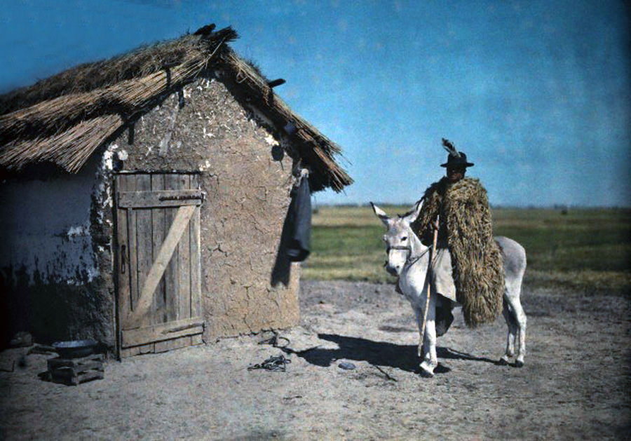 A swineherd sits on a donkey outside a thatched hut in Hortobágy National Park, Hungary, January 1930.