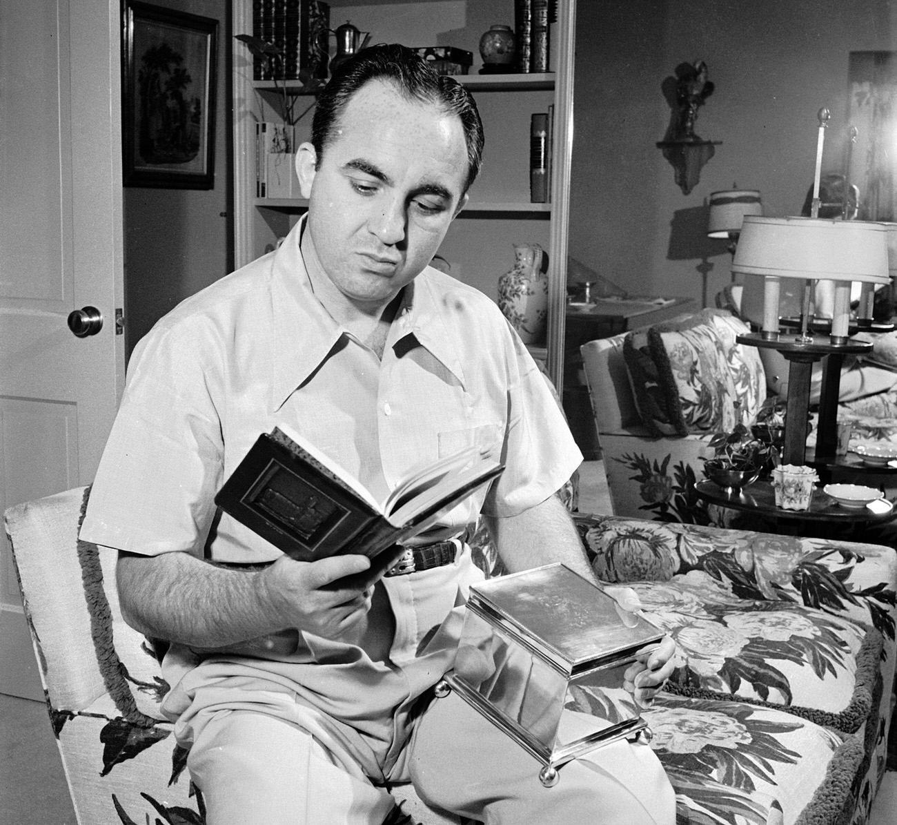 Mickey Cohen at home with a book given to him by the Hebrew Committee of National Liberation, Los Angeles, 1949.