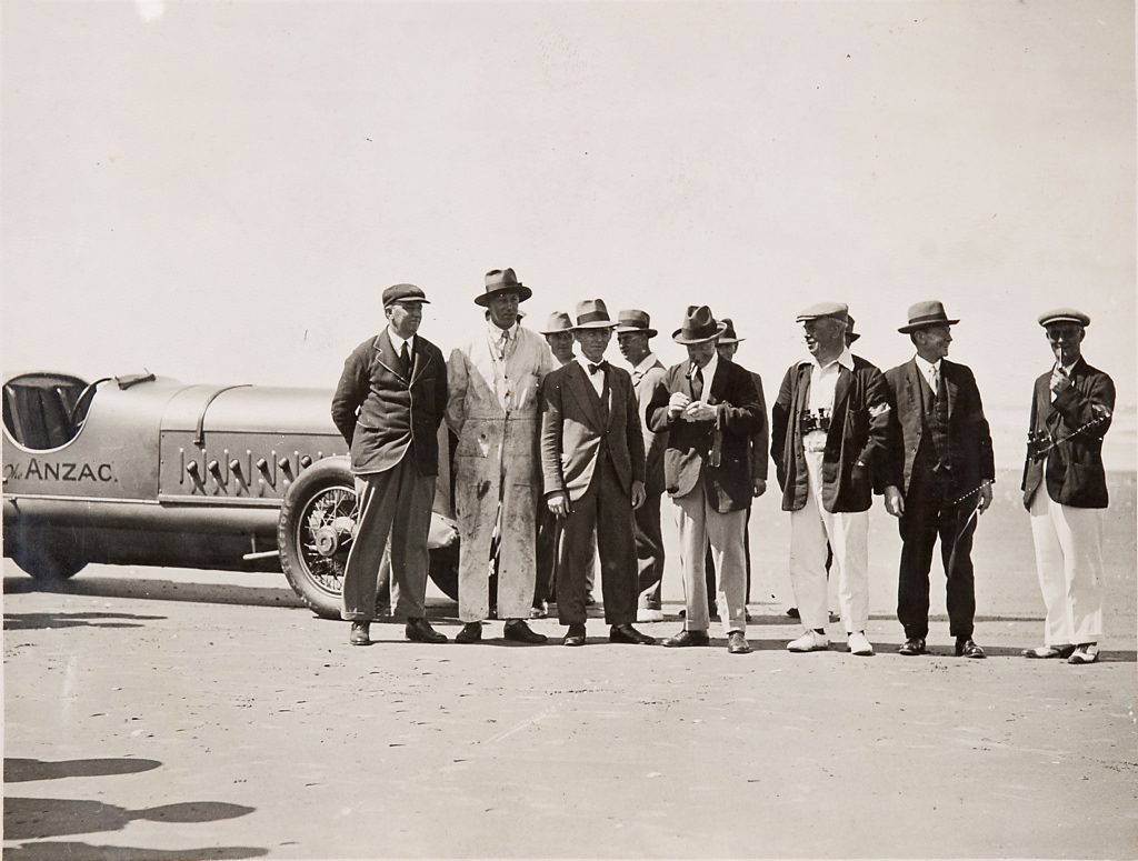 Men on beach with Anzac car