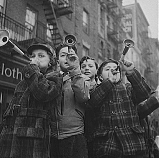 Children blowing horns on Bleecker Street on New Year's Day, 1943.