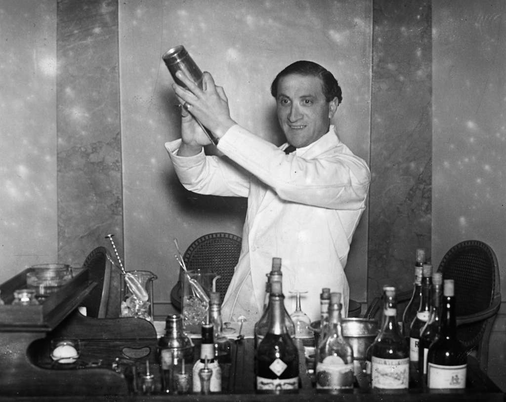 A barman preparing a cocktail at Hector's Devonshire Restaurant, London, on New Year's Eve, 1930.