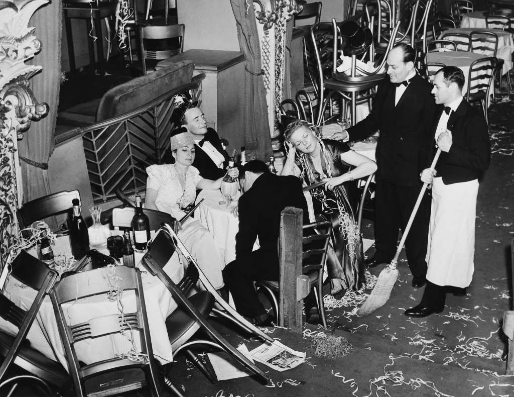 Employees of the Diamond Horseshoe cleaning up after a New Year's Eve party, New York City, 1940.