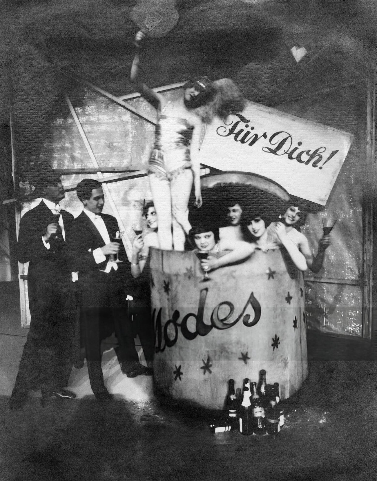 Women with champagne glasses in a wine barrel at the "For You" revue in Berlin, 1926.