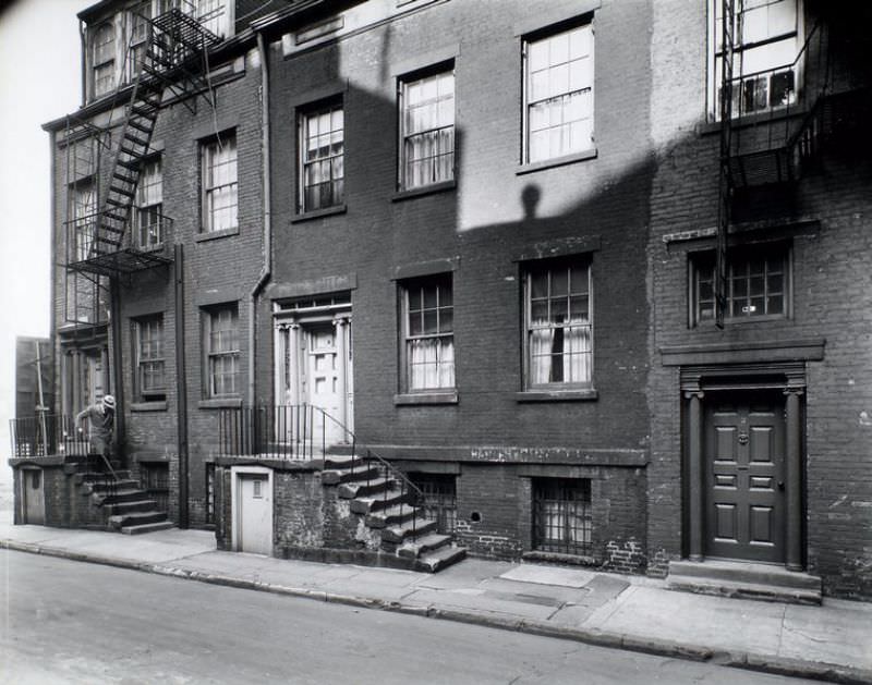 Minetta Street, Nos. 2, 4, 6, Manhattan. Man descends steps of #2 Minetta street, doorways of each house are adorned with ionic columns.