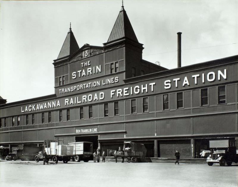 Lackawanna Railroad Freight station, pier 13, trucks and a wagon in front.