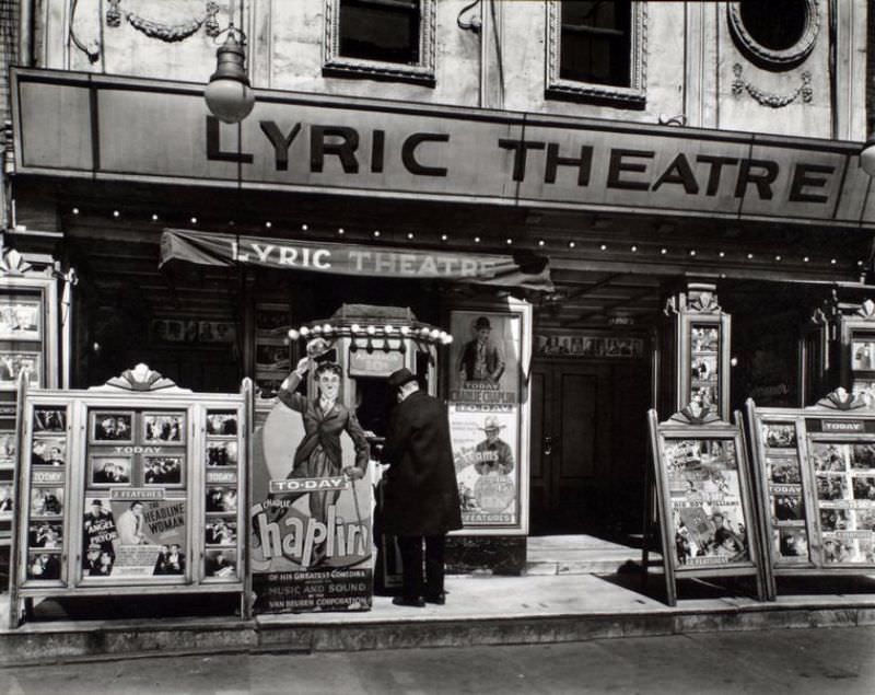 Box office and marquee of Lyric theater, man purchusing ten cent ticket, posters, including life-size cutout of Charlie Chaplin on display.