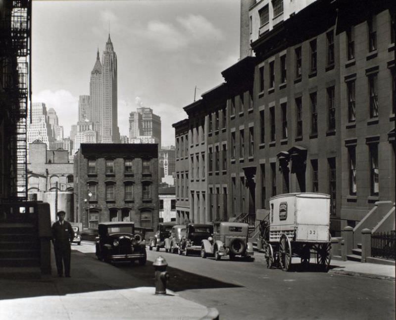 Willow and Poplar Street, looking east [sic, view is actually looking toward Manhattan], Brooklyn. Laundry wagon, cars, along sloping street lined with rowhouses, skyline of Manhattan visible above buildings at end of the street.