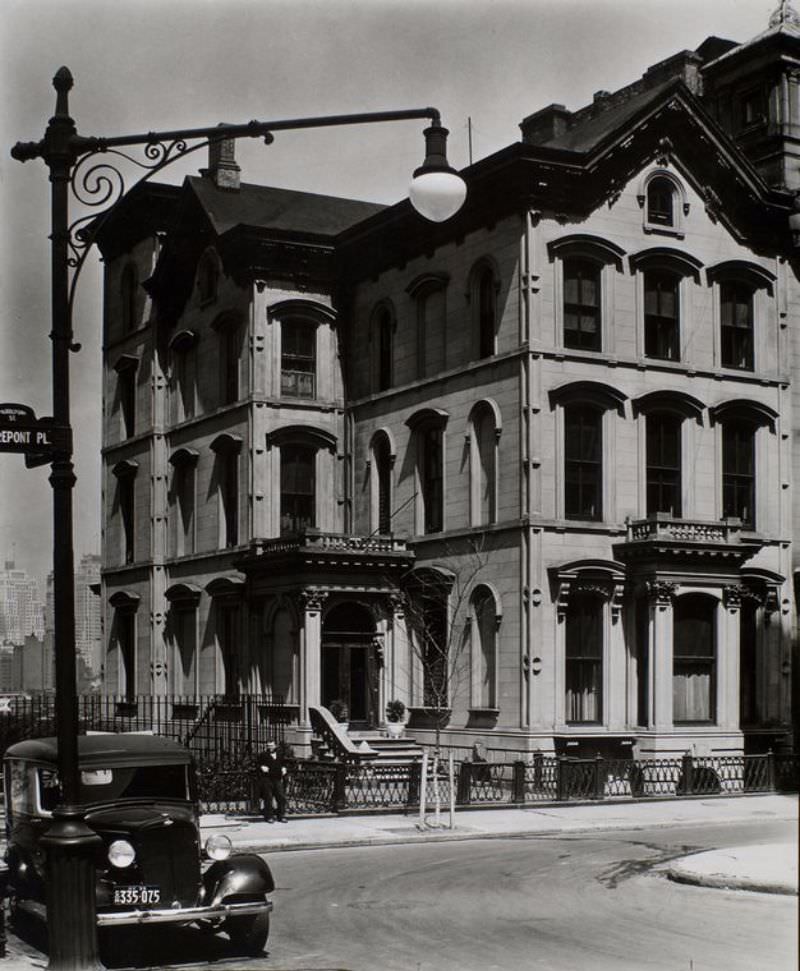 Columbia Heights no. 222, Brooklyn. Large three story house with small windows in fourth story gables, inverted U crowns on windows, asymetrical shape, Manhattan skyline beyond.