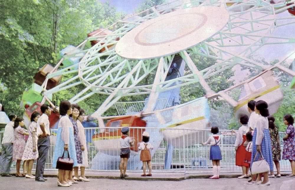 Parents watch their children take a ride on the funfair at Taesongsan in 1980. The park was first opened in 1977 and features 10 rides, though its main rollercoaster was damaged by flooding in 2007 and does not operate.