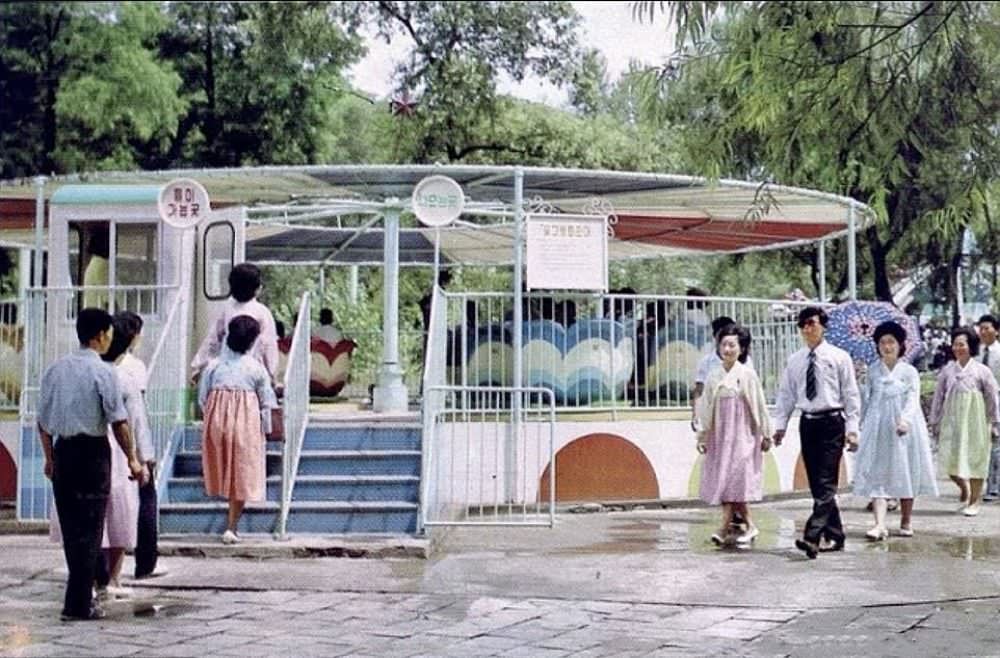 Men and women queue to go on the teacup rise at Taesongsan Funfair some time in the 1980s. The theme park has been updated little since it was first built, and now struggles to operate.