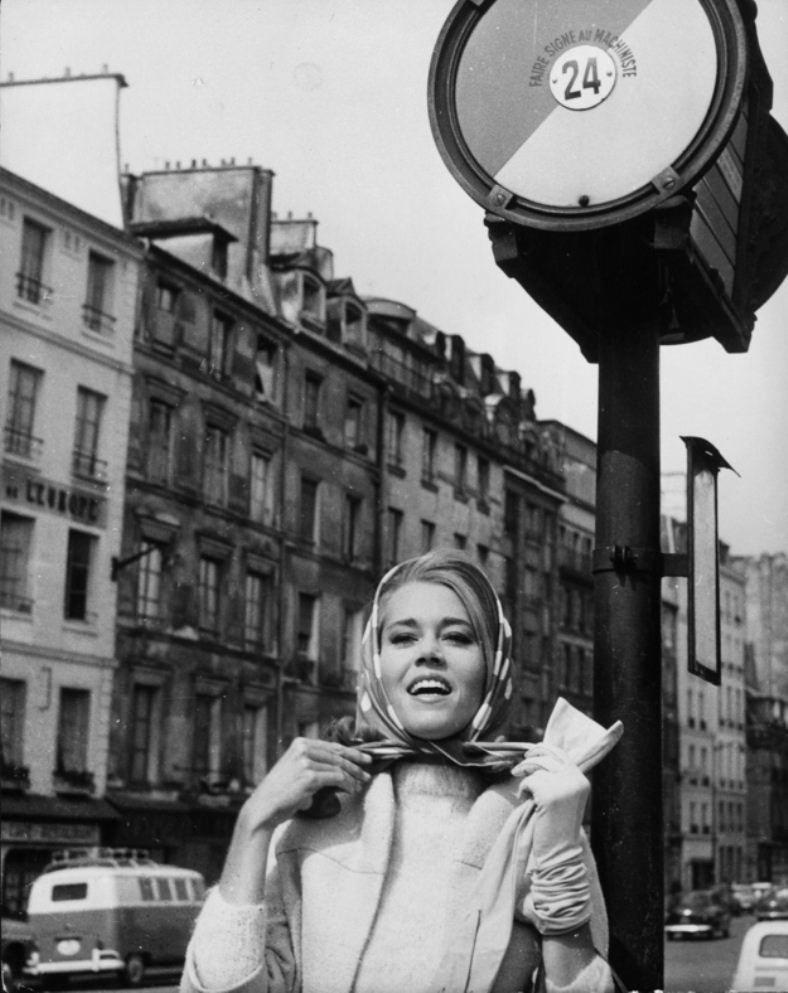 On a visit to Paris, Jane Fonda demonstrates the single-gloved scarf-tying technique, a very difficult French move to master, 1963.