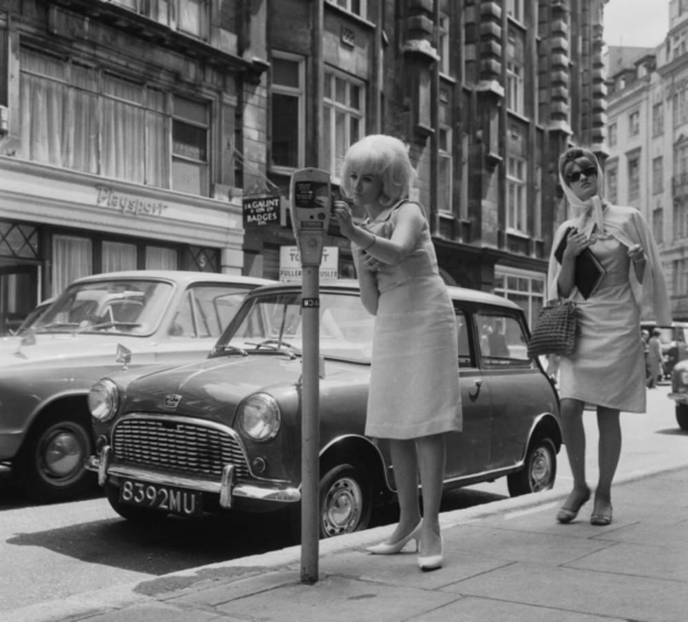 A woman tries to work one of those new-fangled “parking meters,” 1964.