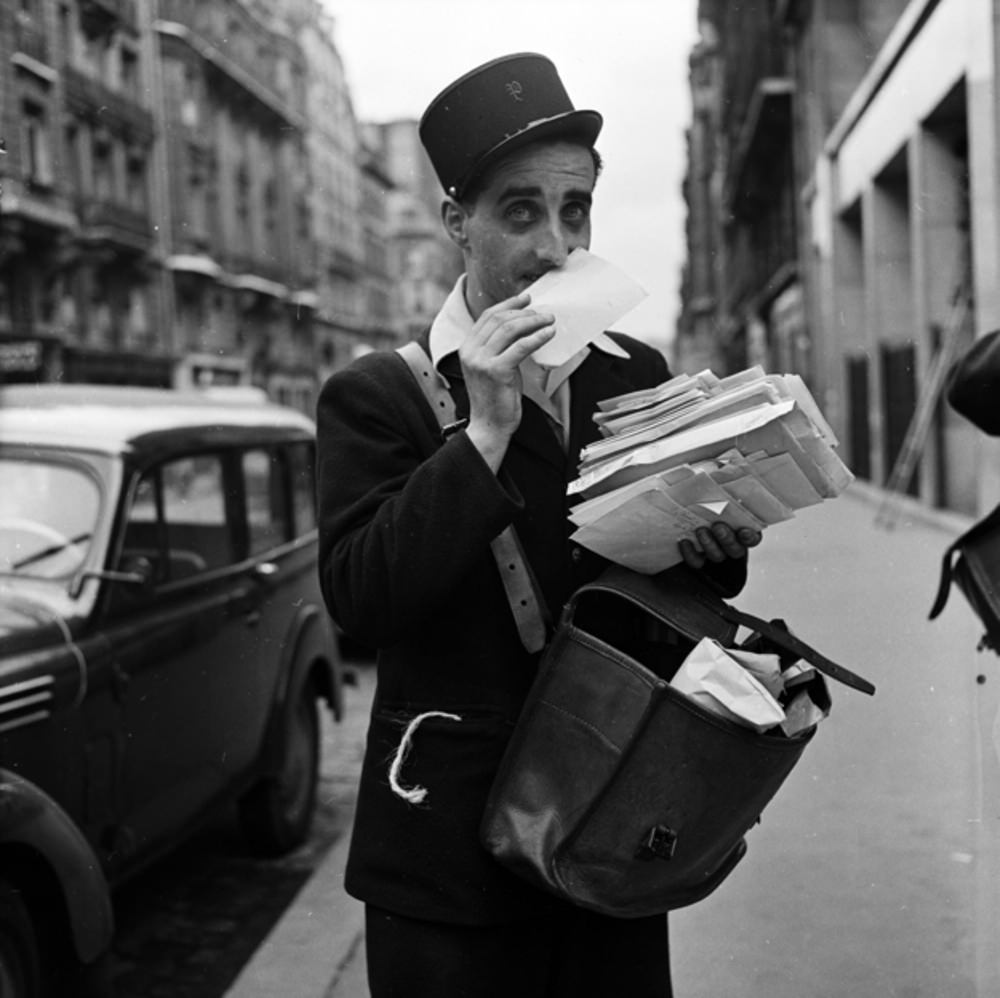 A French postal worker makes sure to smell each envelope before delivery to ensure it has been spritzed with the right amount of Chanel No. 5, 1956.