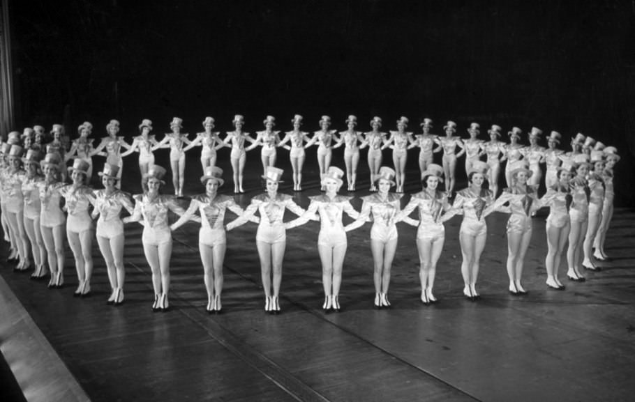 In white satin and jaunty hats, the group forms a perfect circle at Radio City in December of 1944.