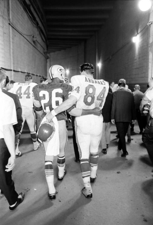 The Packers' Herb Adderley and Kansas City's tight end Fred Arbanas head to the lockers after Green Bay's 35-10 victory in Super Bowl I, Los Angeles, 1967