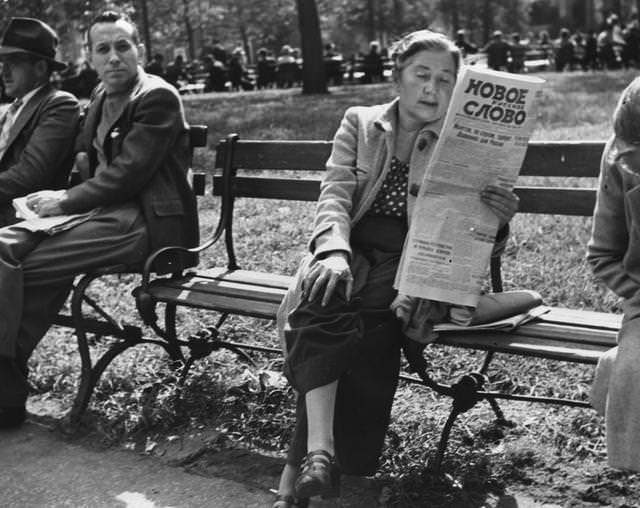 A woman reading a newspaper in Washington Square Park, Greenwich Village, 1955.