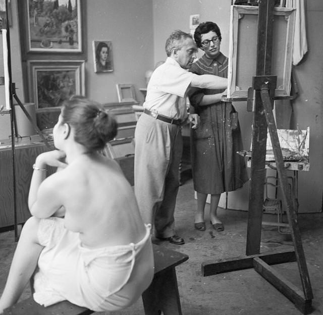 American artist Moses Sawyer instructing a pupil in life model painting in his Greenwich Village studio, 1955.