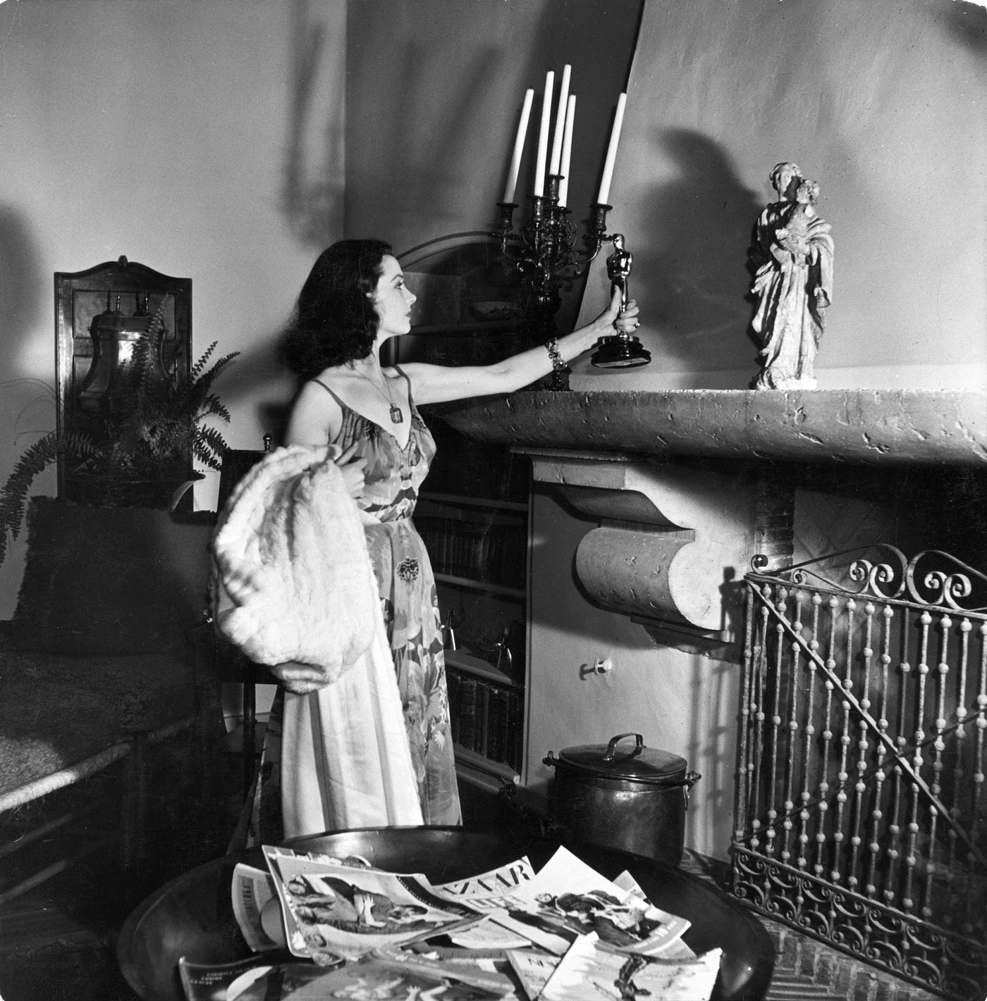 Vivien Leigh places the Oscar she won for her role as Scarlett in Gone With The Wind on her mantlepiece at home, 1940.