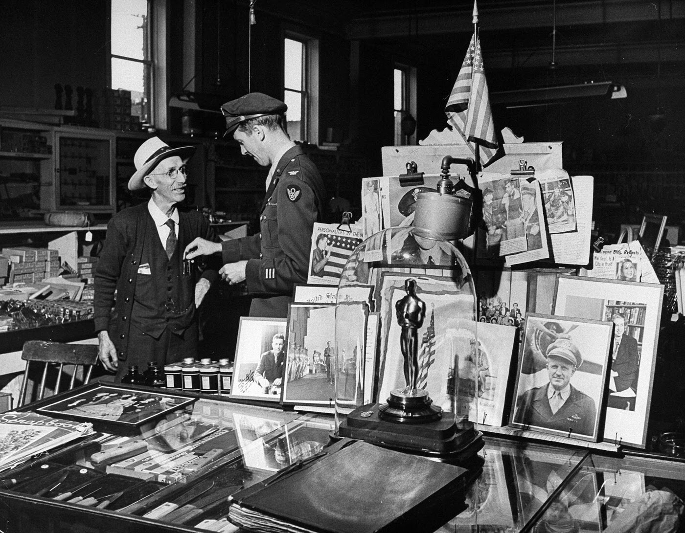 Jimmy Stewart, back from WWII, talks with the oldest employee of his family's hardware store in Pennsylvania, George Little; nearby is a table of various mementos, including Stewart's Best Actor Oscar for The Philadelphia Story.