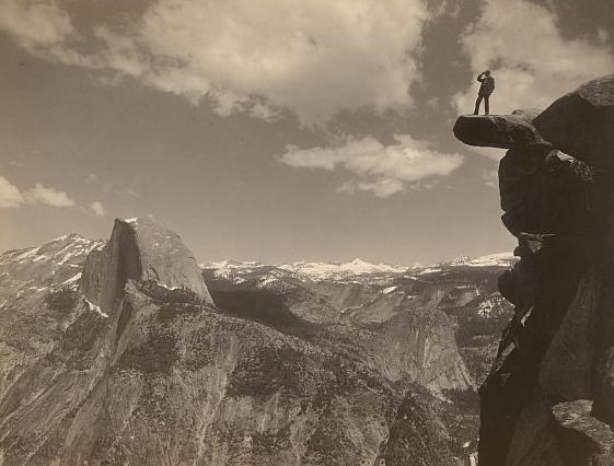 Man standing on Glacier Point, facing Half Dome in Yosemite National Park, California, ca. 1901.